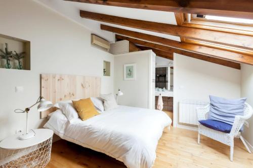 - une chambre avec un lit blanc et des plafonds en bois dans l'établissement Dúplex Unico en Ópera - Palacio, à Madrid