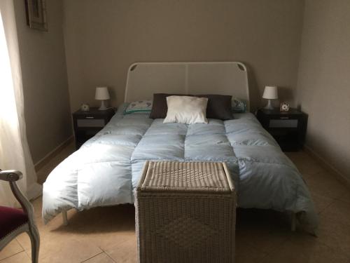 a bed with a blue comforter and two night stands at Villa con piscina in Mascalucia