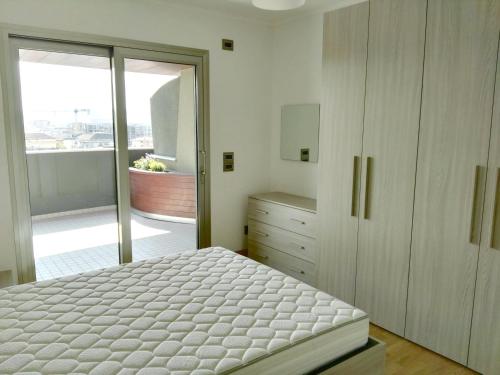 a bedroom with a bed and a sliding glass door at Torri Camuzzi Exclusive Luxury Apartment in Pescara