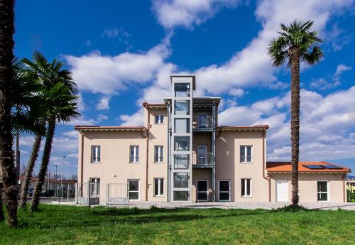 a large house with palm trees in front of it at Ostello La Salana in Capannori