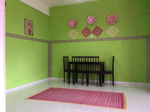a dining room with a table and a green wall at Pangkor Damai in Pangkor