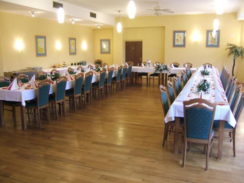 einen Bankettsaal mit Tischen, Stühlen und weißen Tischdecken in der Unterkunft Hotel YORK in Pilsen