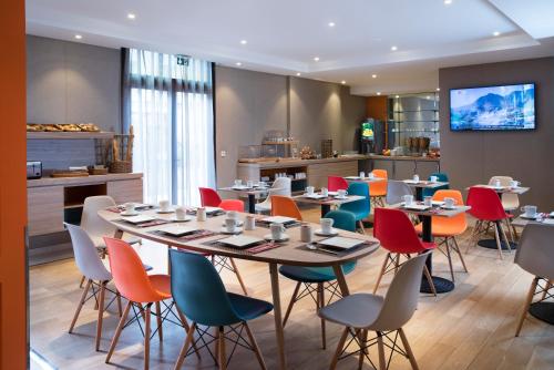 ブール・ラ・レーヌにあるibis Styles Bourg La Reineのダイニングルーム(テーブル、カラフルな椅子付)