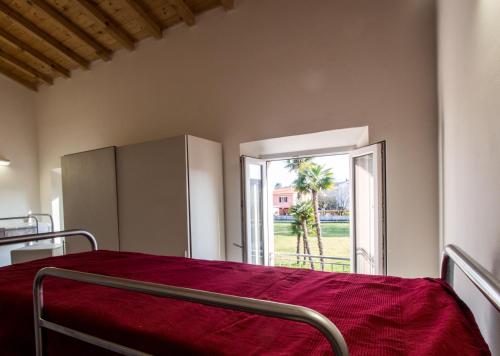 a bedroom with a bed with a red blanket at Ostello La Salana in Capannori