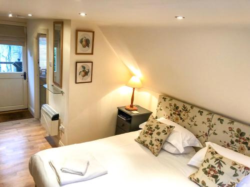 a bedroom with a bed and a lamp on a table at The Apple Loft in Westleton