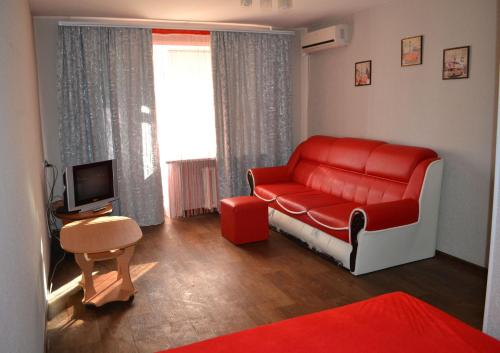 ザポリージャにあるApartment Universitetskaya 54のリビングルーム(赤いソファ、テレビ付)