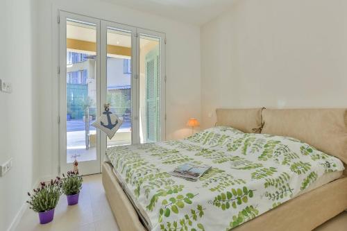 a bedroom with a bed and a window and plants at MY CASA FRANCE 82 TP - Terrace AC & Parking in Nice