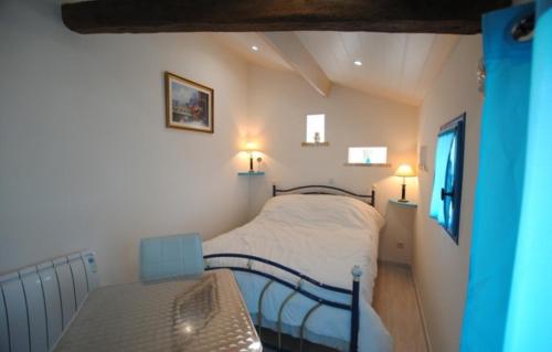 a small bedroom with a bed and a bench in it at Le pigeonnier in Dampierre-le-Château