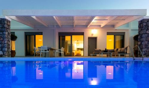 a large swimming pool with chairs and a living room at Villa Serene with swimming pool in Lindos in Líndos
