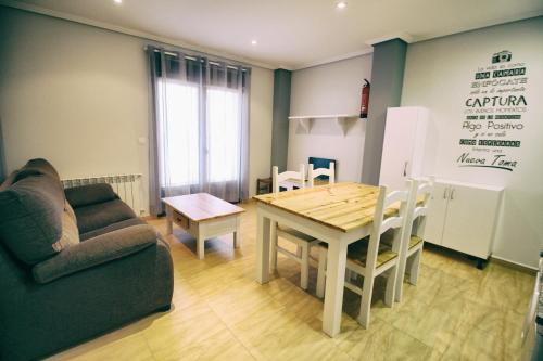 a living room with a table and a couch at Apartamentos La Fuente de Enmedio in Suances