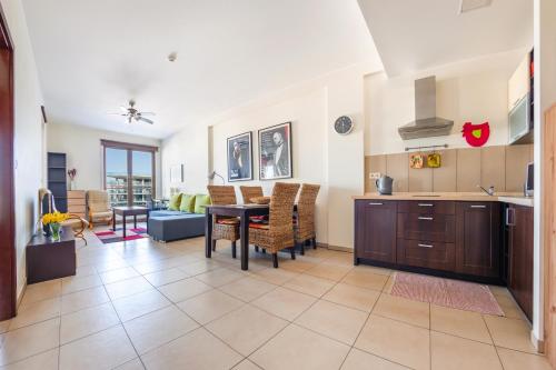 a kitchen and living room with a table and chairs at Olympic Park I, Sun & Snow in Kołobrzeg