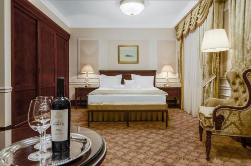 
a hotel room with a bed, table and a wine glass at Nobil Luxury Boutique Hotel in Chişinău

