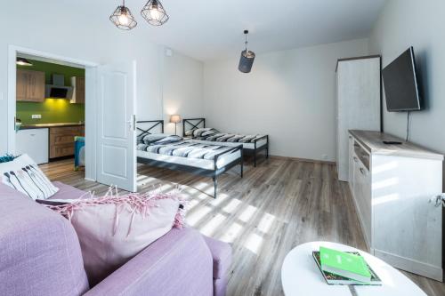 a living room with a purple couch and a table at Lake & City Apartments in Giżycko
