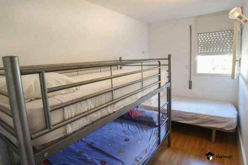 1 dormitorio con 2 literas y ventana en Camelies Apartament per 5 persones a 5 minuts de la Cala Rovira i a poca distància del centre de Platja d'Aro, en Platja d'Aro