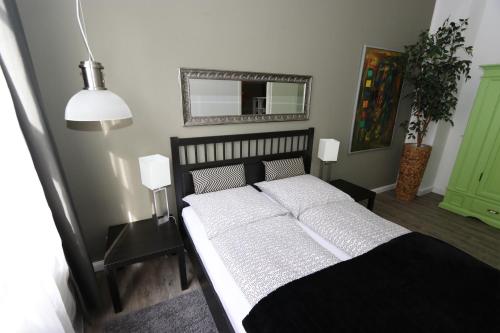 Schlafzimmer mit einem schwarzen und weißen Bett und einem Spiegel in der Unterkunft Loft Wernigerode Erdgeschoss in Wernigerode