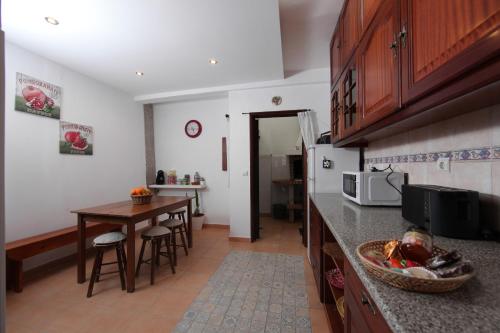 a kitchen with a table and a counter top at Casa das Andorinhas in Faro