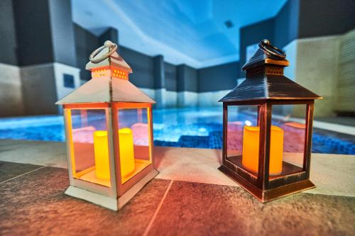 two lanterns sitting next to a swimming pool at Perla Residence Hotel & SPA in Podgorica