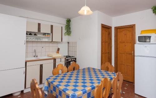 Una cocina con una mesa y sillas en una habitación. en Páratlan Apartmanház, en Szilvásvárad