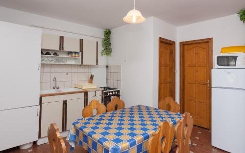 eine Küche mit einem Tisch und Stühlen im Zimmer in der Unterkunft Páratlan Apartmanház in Szilvásvárad