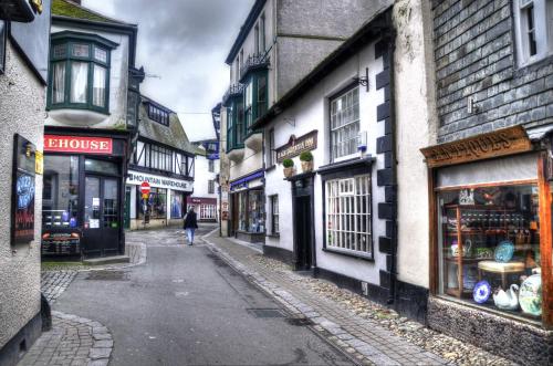 a woman walking down an alley in an old town at Sand Martin in Looe