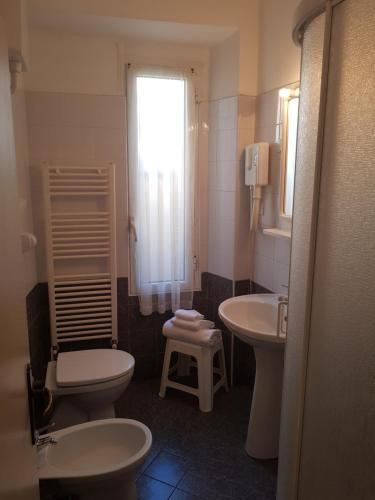 baño con 2 lavabos, aseo y ventana en Hotel Doria, en Varazze