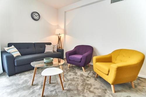 a living room with two chairs and a couch and a table at Perla Residence Hotel & SPA in Podgorica