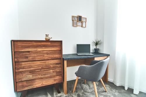 a desk with a laptop and a chair in a room at Perla Residence Hotel & SPA in Podgorica