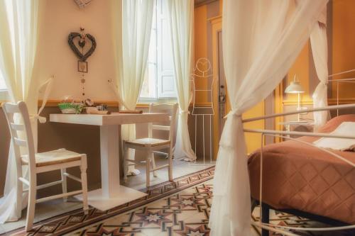 a bedroom with a bed and a desk and a table at Ghibellino B&B in Arezzo