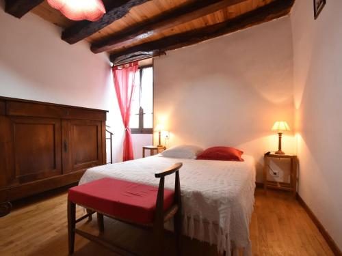 - une chambre avec un lit blanc et un banc rouge dans l'établissement Holiday Home in Dordogne near Castles, à Saint-Germain-de-Belvès