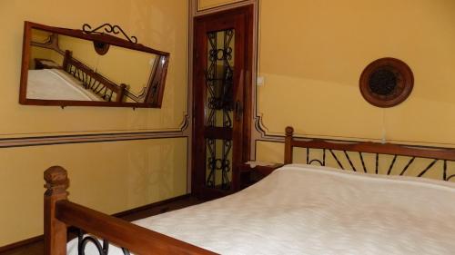 a bedroom with a bed and a mirror on the wall at Dona Guest House - Horse Riding in Koprivshtitsa