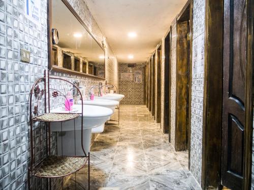 a bathroom with four sinks and a row of mirrors at Seven Wonders Bedouin Camp in Wadi Musa