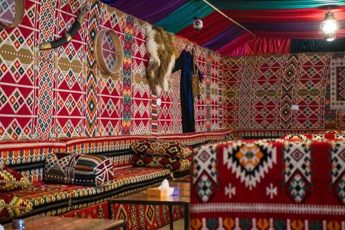 a room with couches and a wall covered in patterns at Seven Wonders Bedouin Camp in Wadi Musa