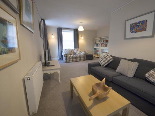 ein Wohnzimmer mit einem Sofa und einem Tisch in der Unterkunft The Gallery Flat, 4 Tannage Brae in Kirriemuir