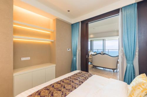 a bedroom with a bed and a view of the ocean at Van-Pretty Residence Haitang Bay Sanya in Sanya