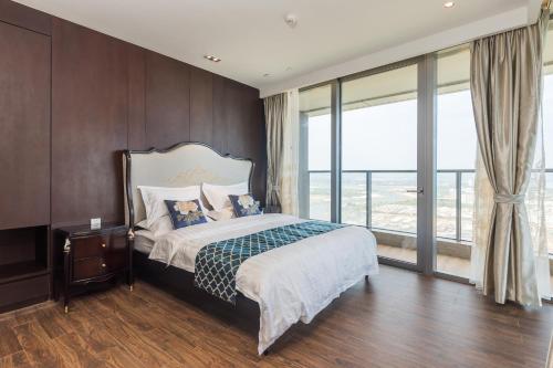 a bedroom with a bed and a large window at Van-Pretty Residence Haitang Bay Sanya in Sanya