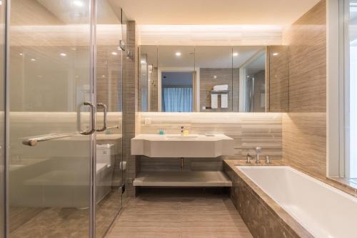 a bathroom with a sink and a shower and a tub at Van-Pretty Residence Haitang Bay Sanya in Sanya