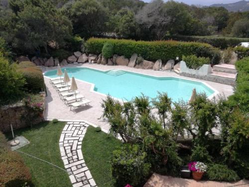 a swimming pool in a yard with chairs and trees at Green Park Hotel in Porto Cervo