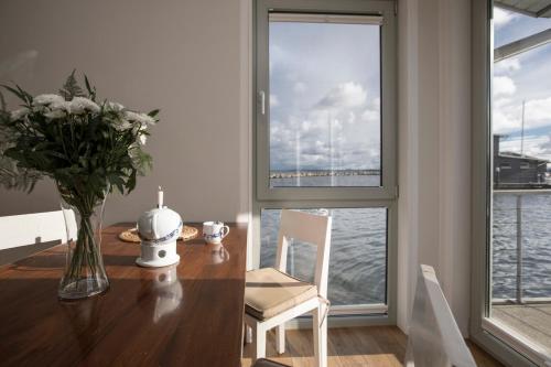 a dining room table with a vase of flowers and a window at Im-Jaich Wasserferienwelt in Lauterbach