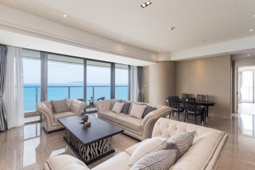 a living room with couches and a table at Van-Pretty Residence Haitang Bay Sanya in Sanya