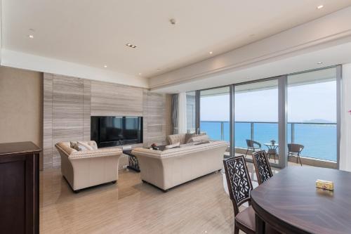 a living room with a couch and a television at Van-Pretty Residence Haitang Bay Sanya in Sanya