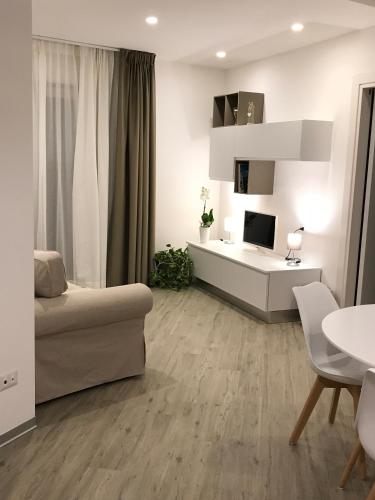 a white living room with a couch and a table at A Matera "Sotto i pini" in Matera