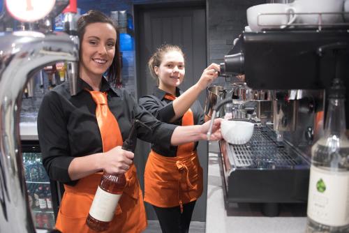 two women are making coffee in a coffee shop at The Davron Hotel in Fraserburgh