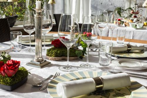 a table with a white table cloth with wine glasses at Romantik Hotel Zum Rosenhof in Hesserode