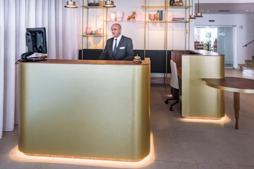 a man in a suit sitting at a reception desk at Bel Air in Castelldefels