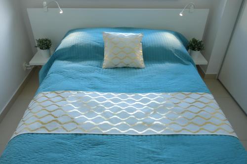ソポトにあるPolna Apartのベッド(青と白のシーツ、枕付)