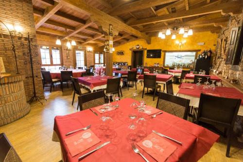 a dining room with red tables and chairs at Apartamentos Turísticos EL Duende de Carricuende in Puente-Almuhey