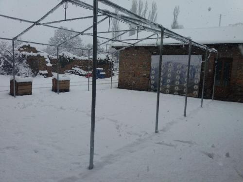 a greenhouse covered in snow in front of a building at Apartamentos Turísticos EL Duende de Carricuende in Puente-Almuhey