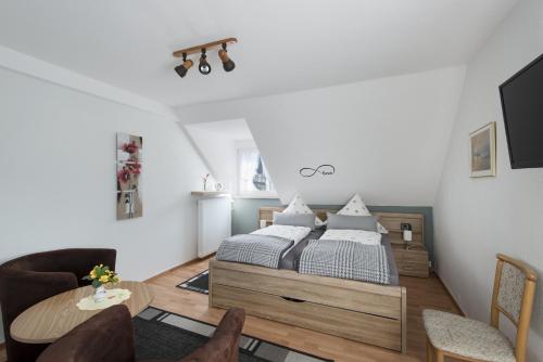 sypialnia z łóżkiem, stołem i krzesłami w obiekcie Wein & Gästehaus Ballmann w mieście Trittenheim