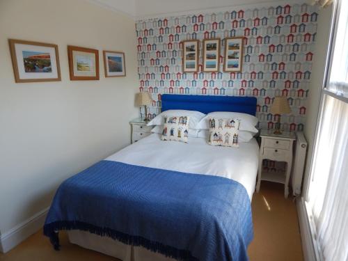 a bedroom with a blue and white bed and a window at Fairlight Lodge in King's Lynn