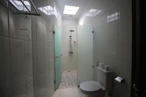 a bathroom with a toilet and a shower at The Green Kamboja Villa in Sanur
